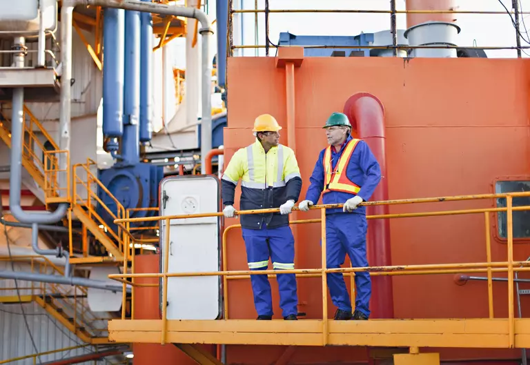 Workers talking on oil rig