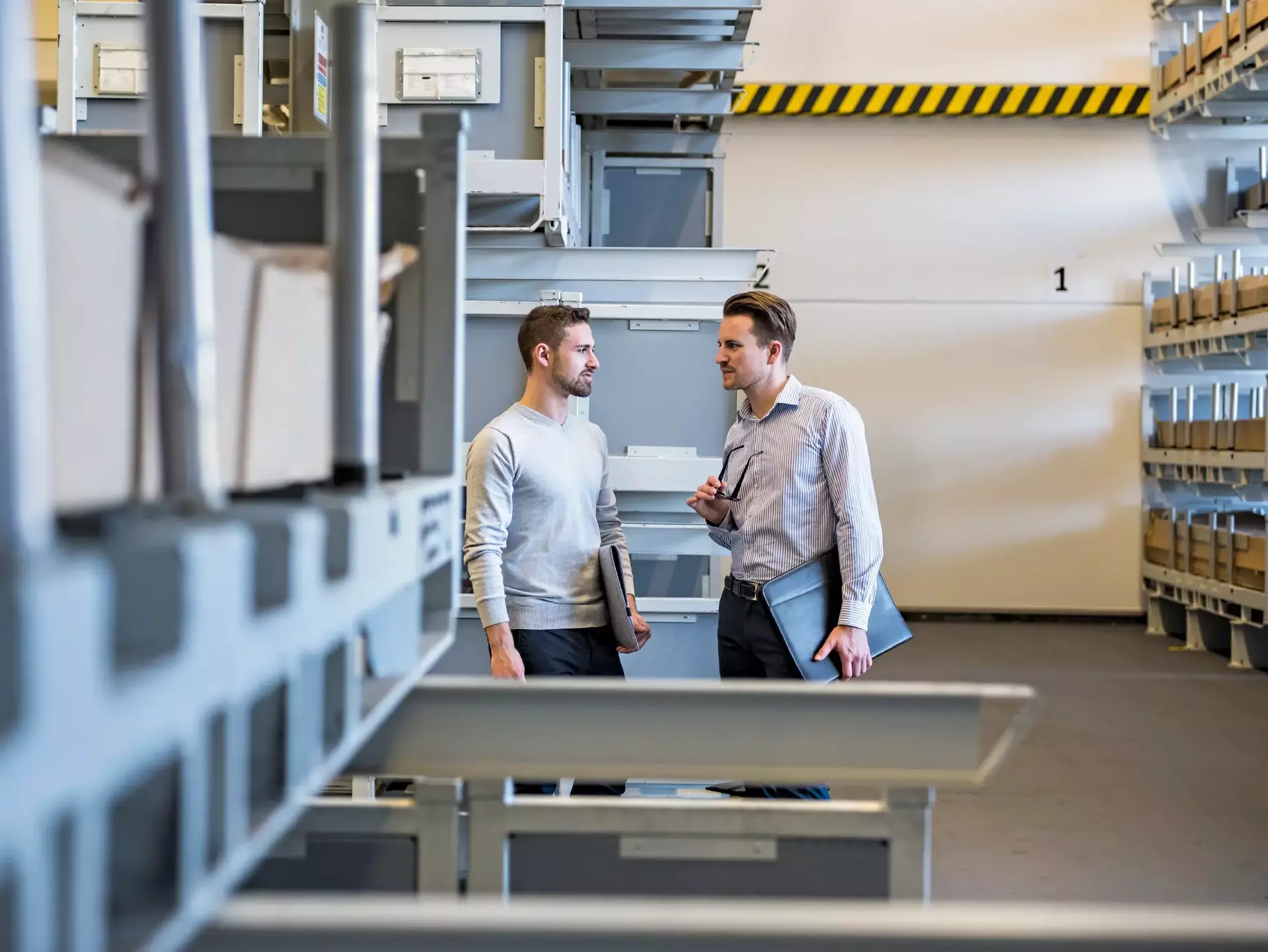 Two men talking in factory warehouse