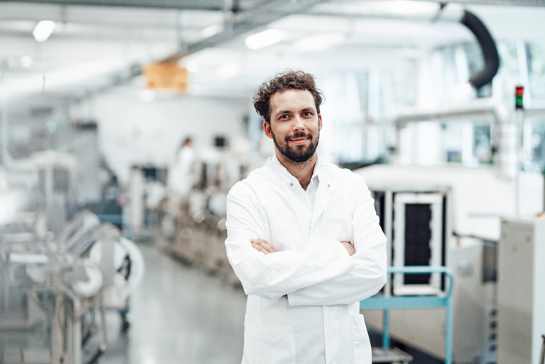 Confident male scientist in white lab coat while standing with arms crossed at bright laboratory Confident male scientist in white lab coat while standing with arms crossed at bright laboratory