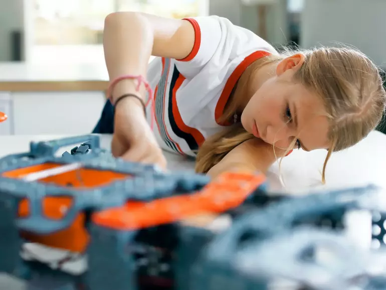 Girl building a robot in workshop Girl building a robot in workshop