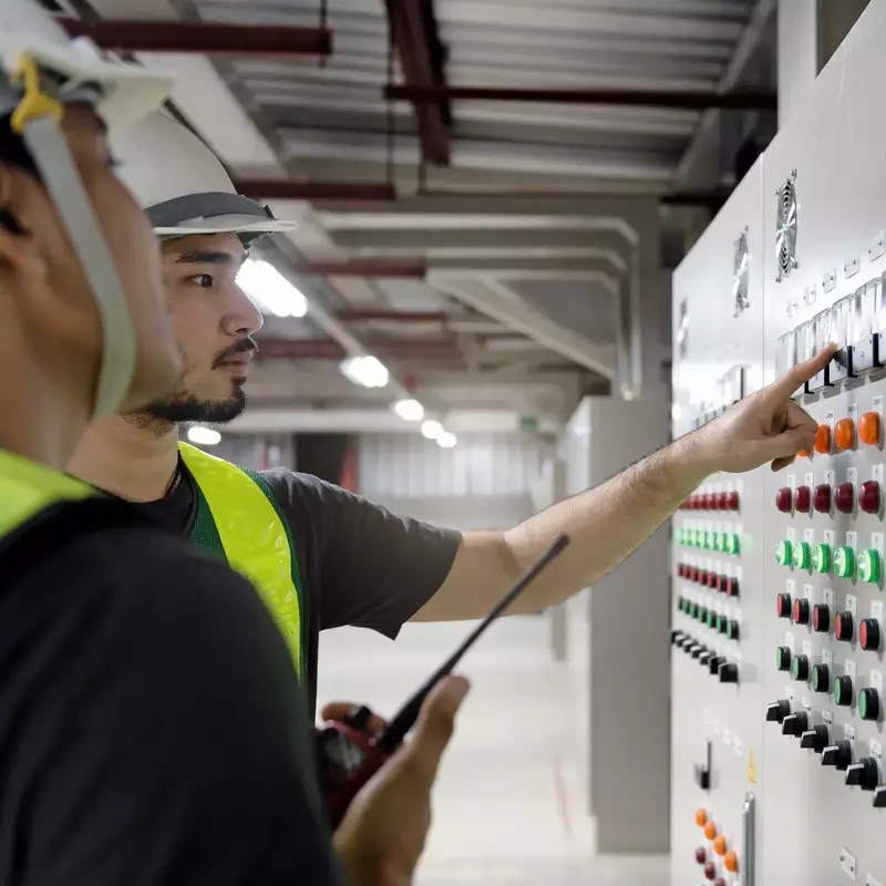 Team von Elektrotechnikern bei der Arbeit an Schalttafeln