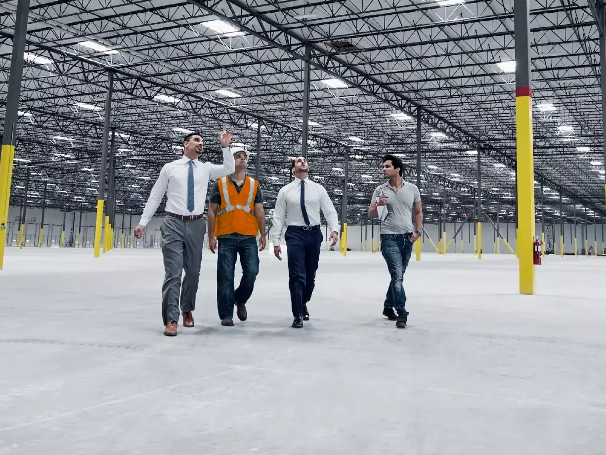 Businessmen walking and talking in empty warehouse Businessmen walking and talking in empty warehouse