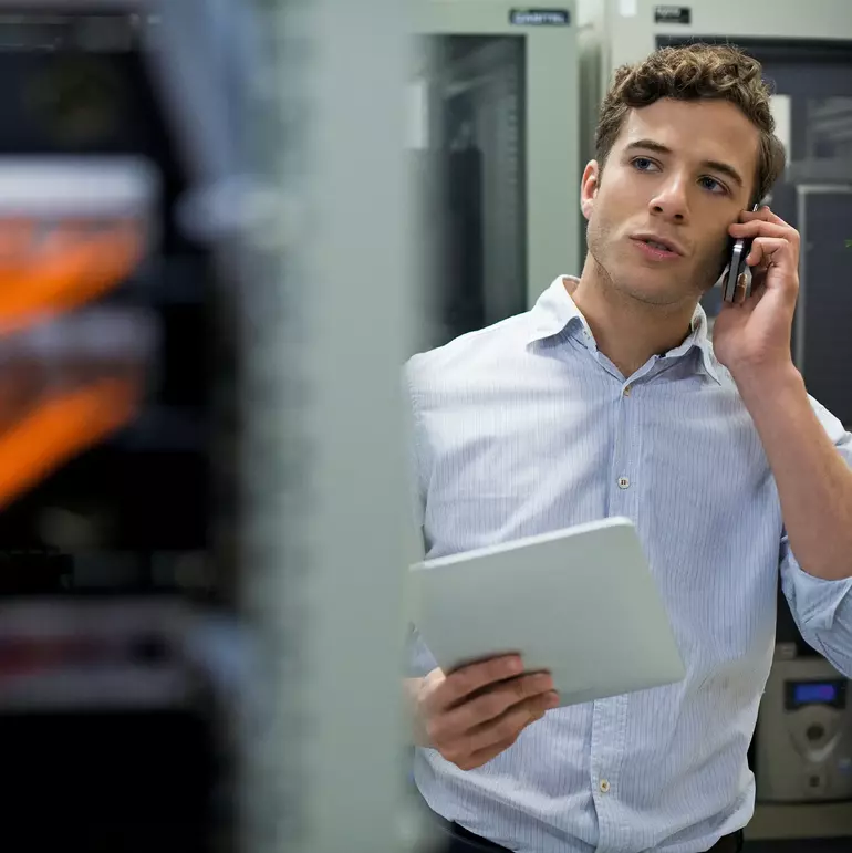 Computer technician performing maintenance check of mainframe equipment