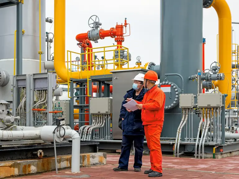 Engineers and staff communicate on site in chemical plant Engineers and staff communicate on site in chemical plant