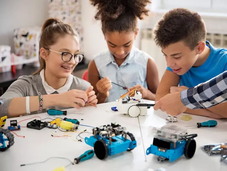Kids working on a robot design Kids working on a robot design